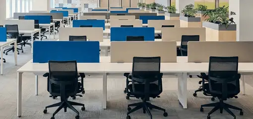 Modern open-plan office space featuring clean workstations, ergonomic chairs, and sanitized carpets provided by professional office cleaning services in Lakeland, FL.